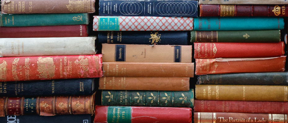 Une pile de vieux livres dont on voit les dos multicolores
