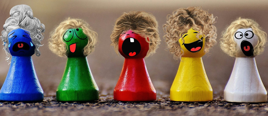 Cinq pions  de jeu de société (bleu, vert, rouge, jaune et blanc)avec des perruques et une expression différente peinte : joie, tristesse, colère...