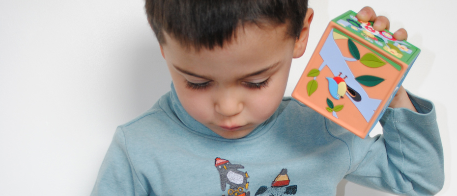 Un enfant qui écoute une boîte à histoires Joyeuse
