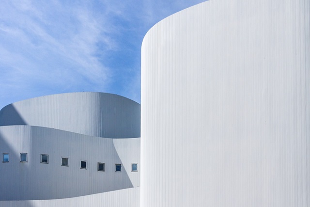 bâtiment blanc architectural ondulé avec un ciel bleu en arrière plan